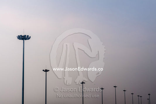Tarmac lighting poles vanishing into the distance at a large airport shrouded in pollution. Chengdu, Sichuan Province, China