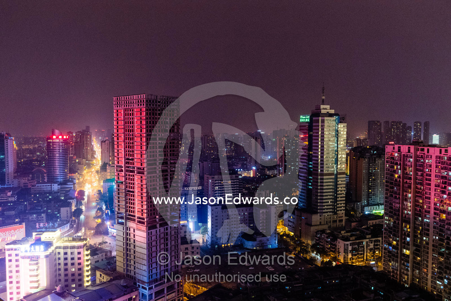 Colorful lights create contrast on the facades of business district office buildings at night. Chengdu, Sichuan Province, China