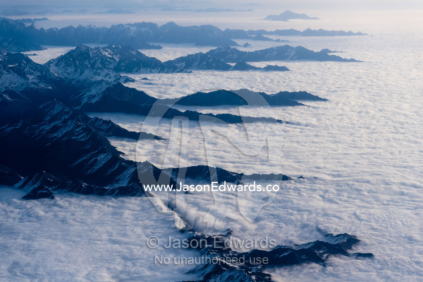 An ocean of cloud fills valleys and flows up to the slopes of the Himalaya Mountains. Tibet Autonomous Region, Tibet