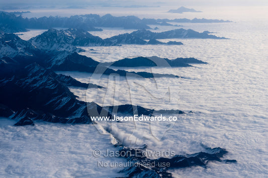 An ocean of cloud fills valleys and flows up to the slopes of the Himalaya Mountains. Tibet Autonomous Region, Tibet
