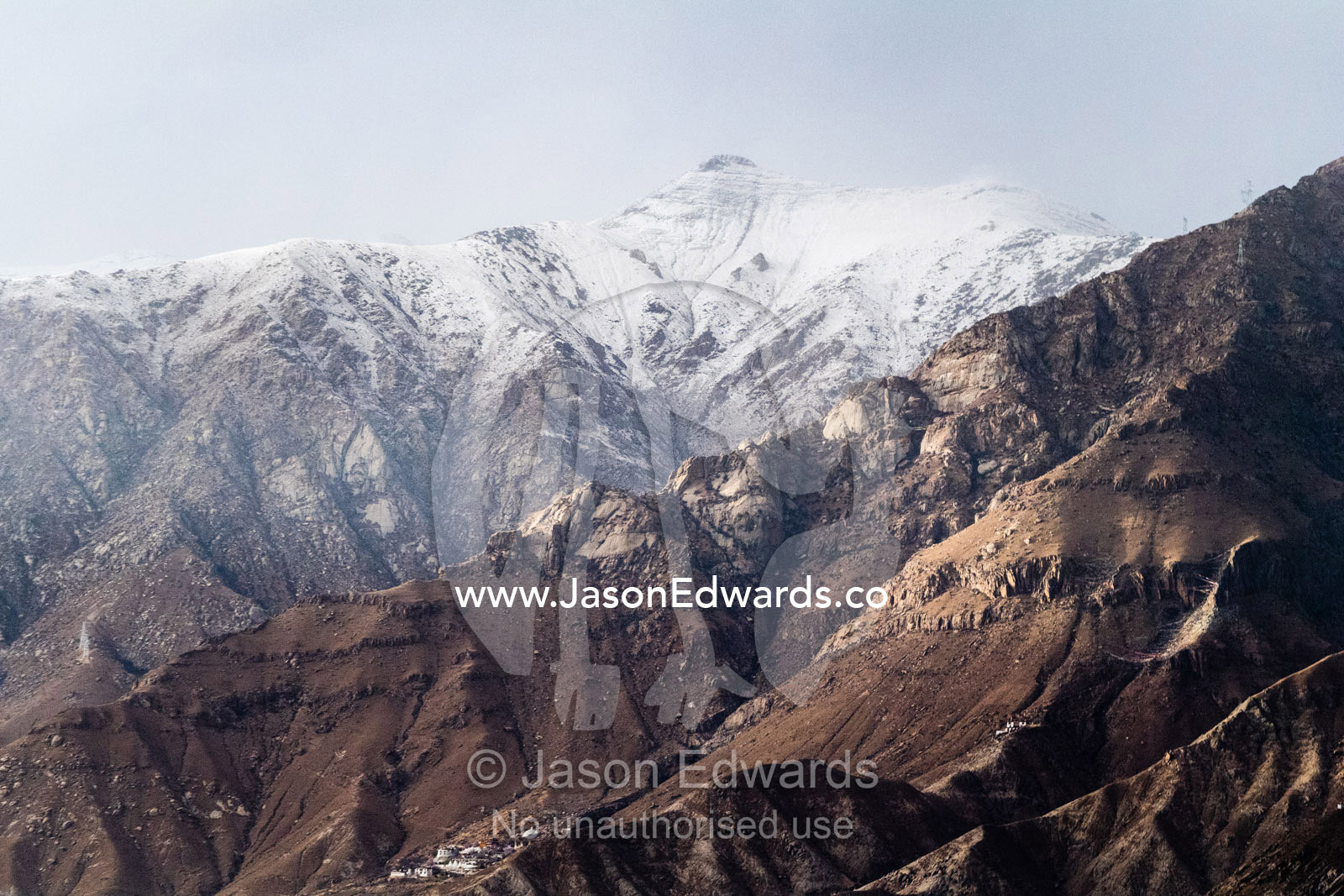 The snowline rises above barren Himalaya foothills during the summer. Lhasa, Tibet Autonomous Region, Tibet