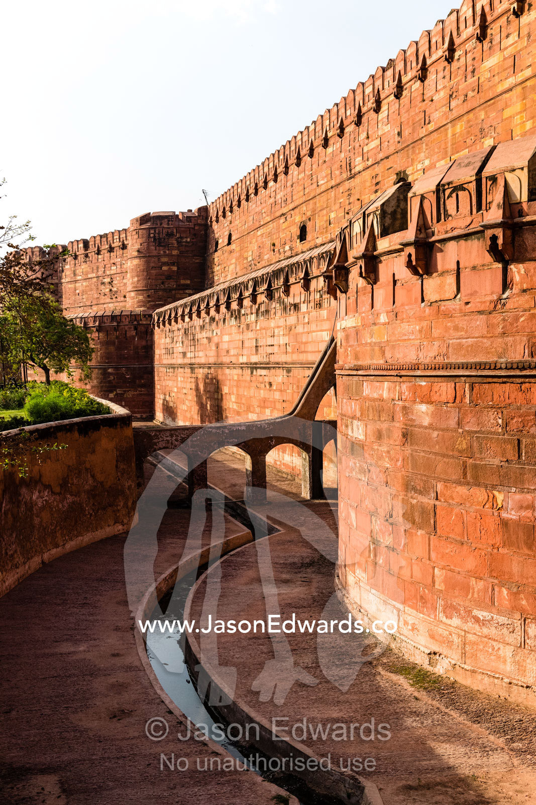 The towering shield wall and wide moat of the Mughal Dynasty Agra Fort. Agra, Agra Fort, Uttar Pradesh, India