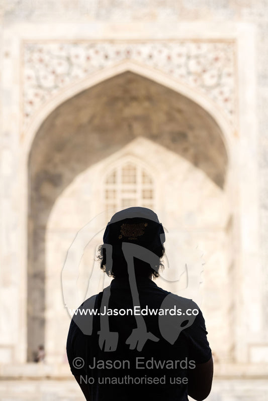 The silhouette of a tourist watching the sunrise over the Taj Mahal. Agra, Taj Mahal, Uttar Pradesh, India