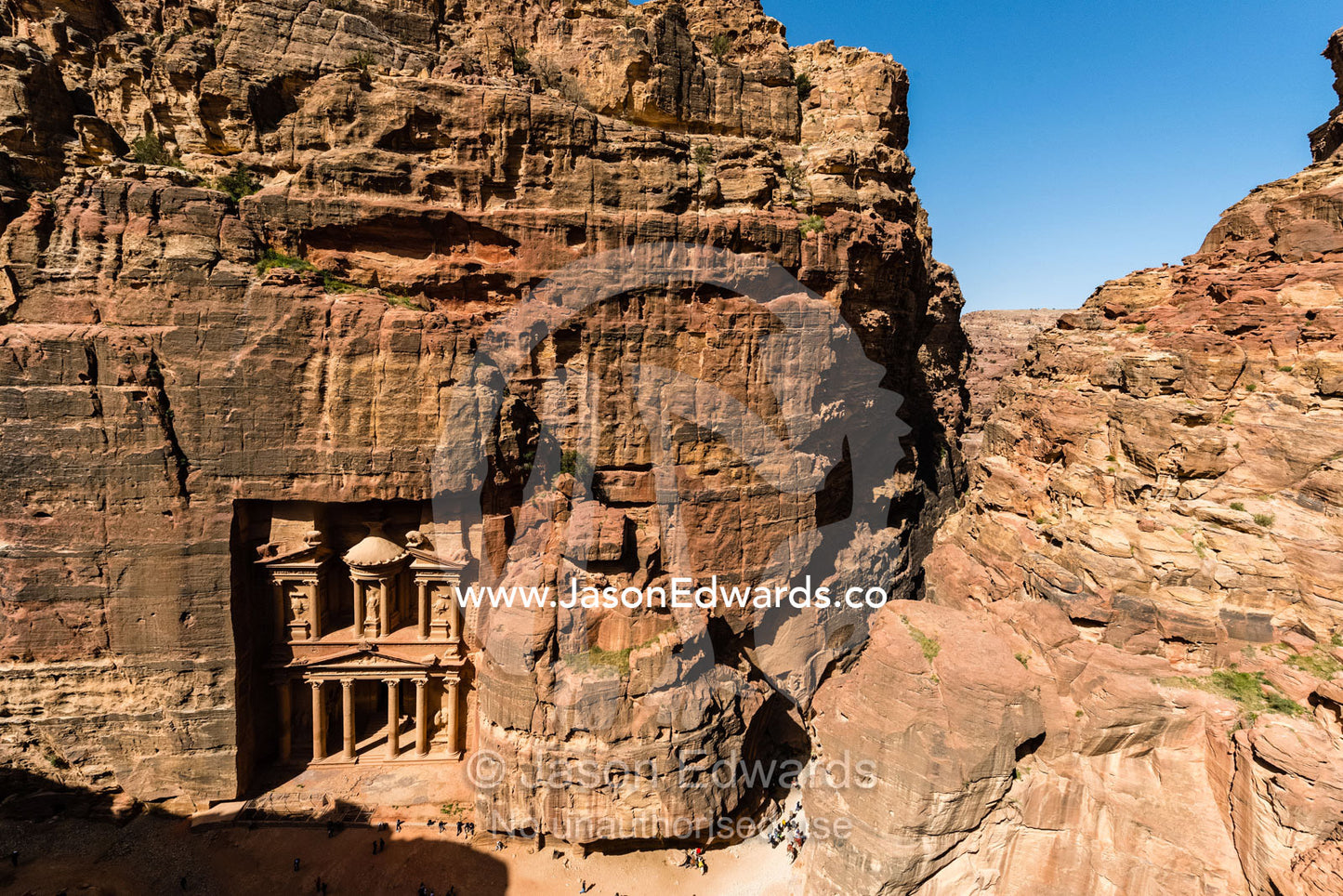 The rock-cut facade of The Treasury tomb showing the enormous columns in a sandstone gorge. Petra, The Lost City of Petra, Jordan