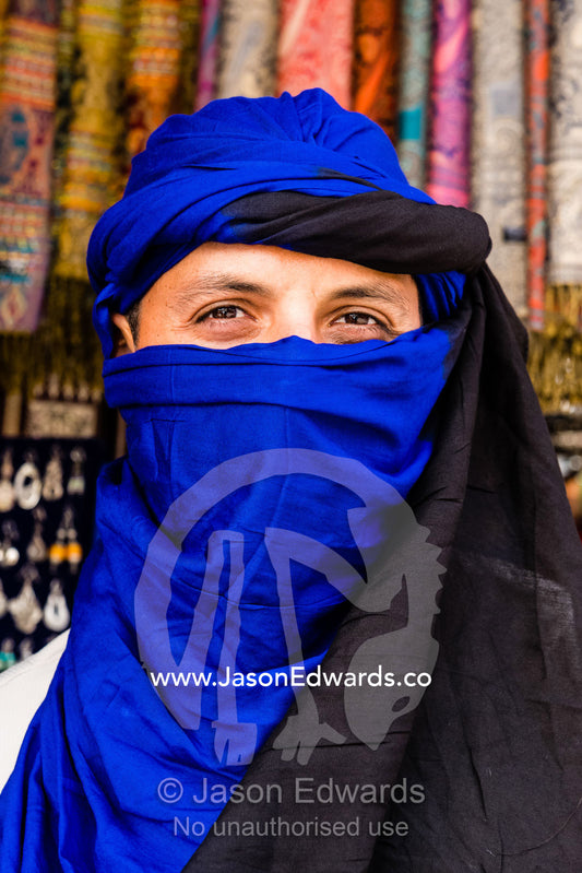 A man wearing a blue Moroccan turban to cover his face. Marrakech, Marrakech Souk, Medina of Marrak, Morocco