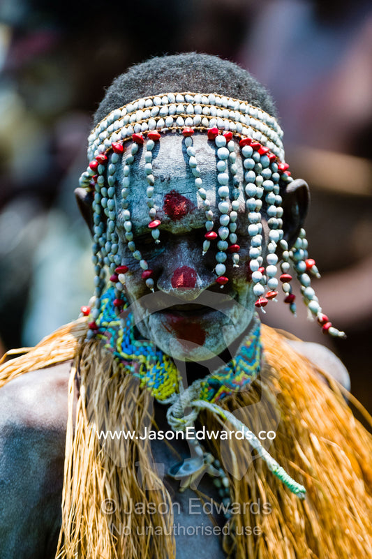 An Asmat woman in war paint wearing a headdress made of seeds and shells. Syuru Village, Asmat Regency, Papua, Indonesia