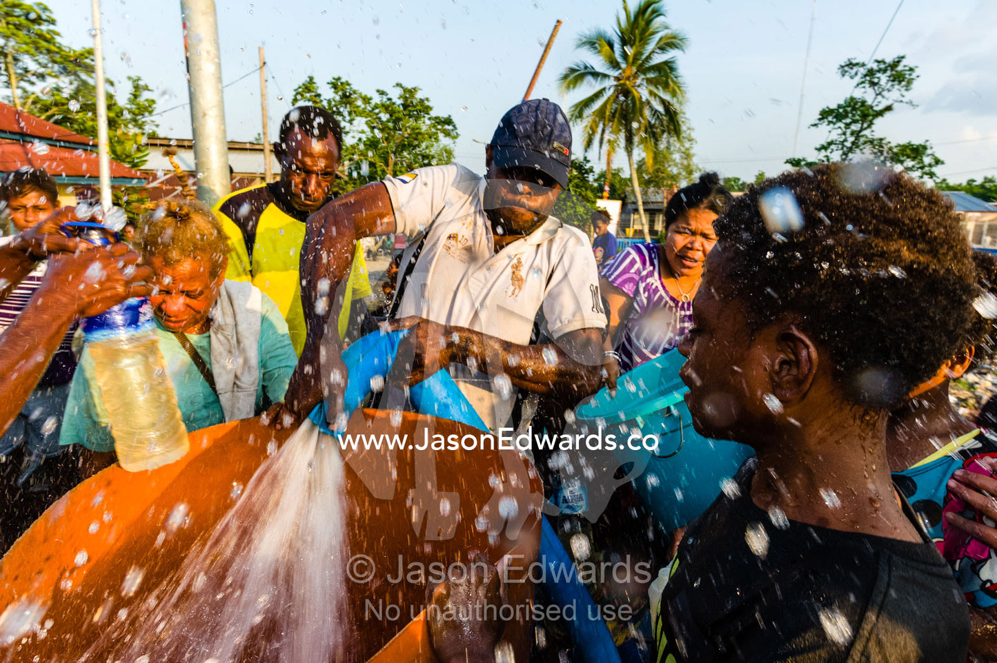 Villagers fight to fill containers with fresh water during a drought in a river town. Agats, Asmat Regency, Papua, Indonesia