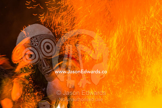 Baining warriors wearing grass and reed outfits and giant duck-like masks taunt the flames and their gods during a tribal fire ceremony. Rabaul, New Britain, Papua New Guinea