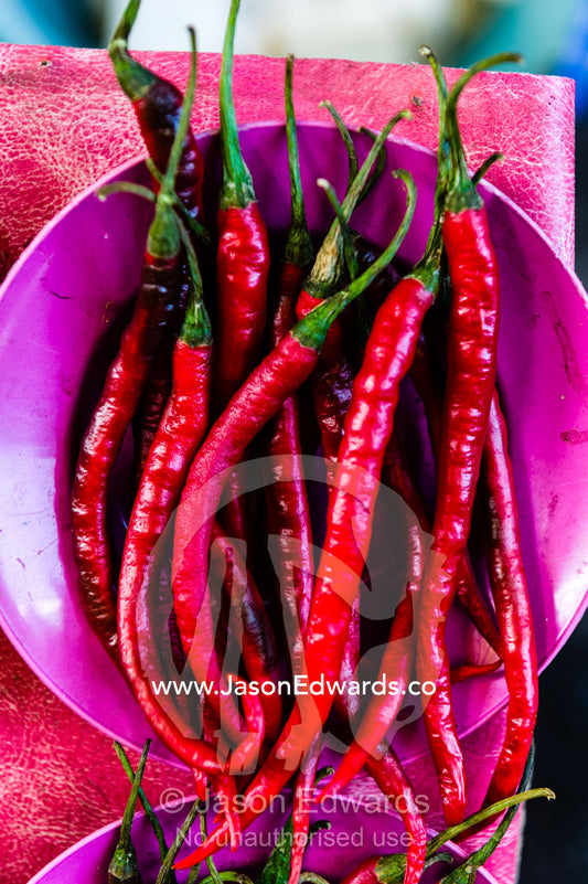 Spicy and hot red chilies for sale in a bowl in an island market. Banda Neira, Banda Islands, West Papua, Indonesia