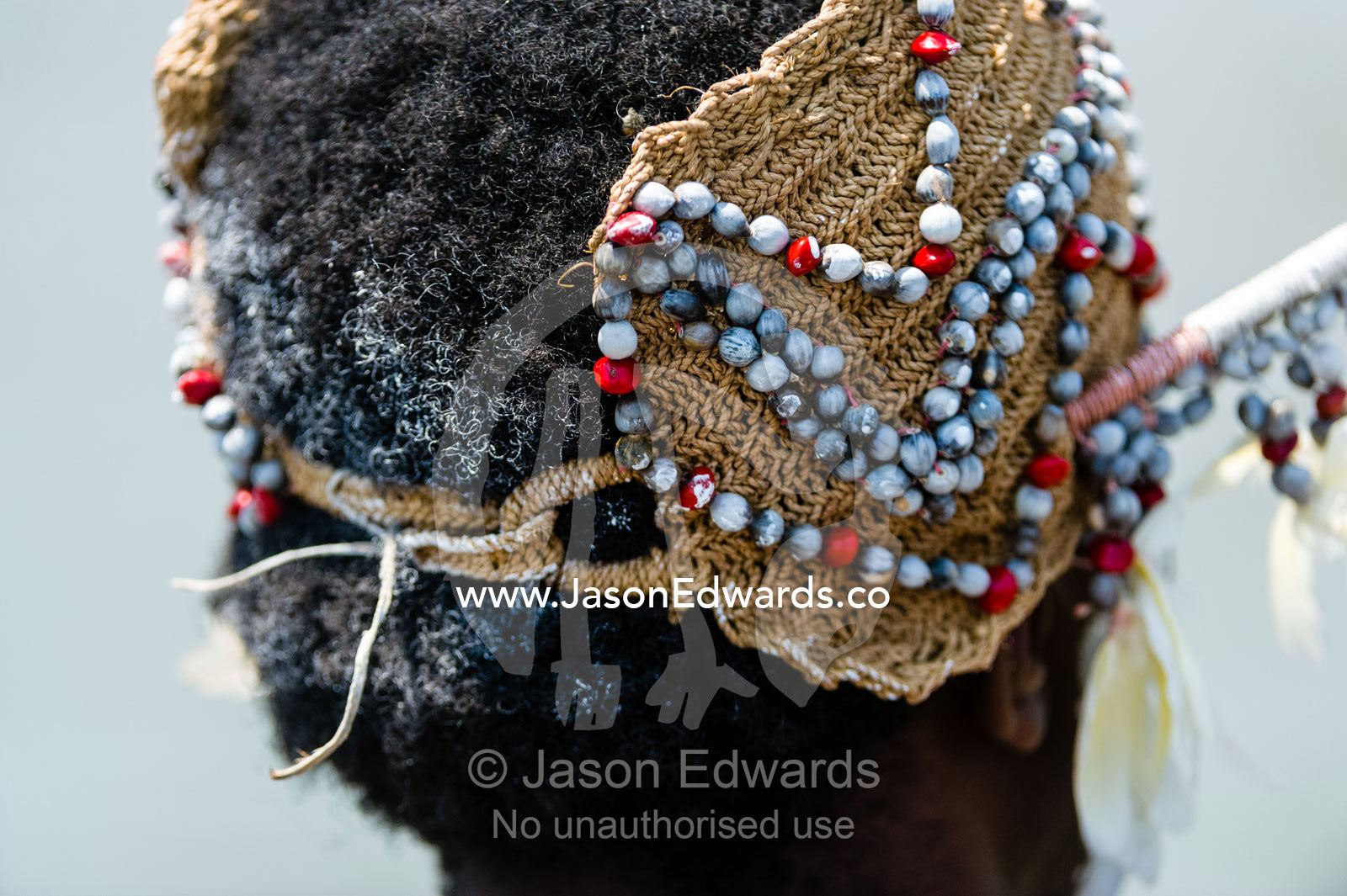 An Asmat warrior wearing a woven headdress decorated with shells and feathers. Syuru Village, Asmat Regency, Papua, Indonesia