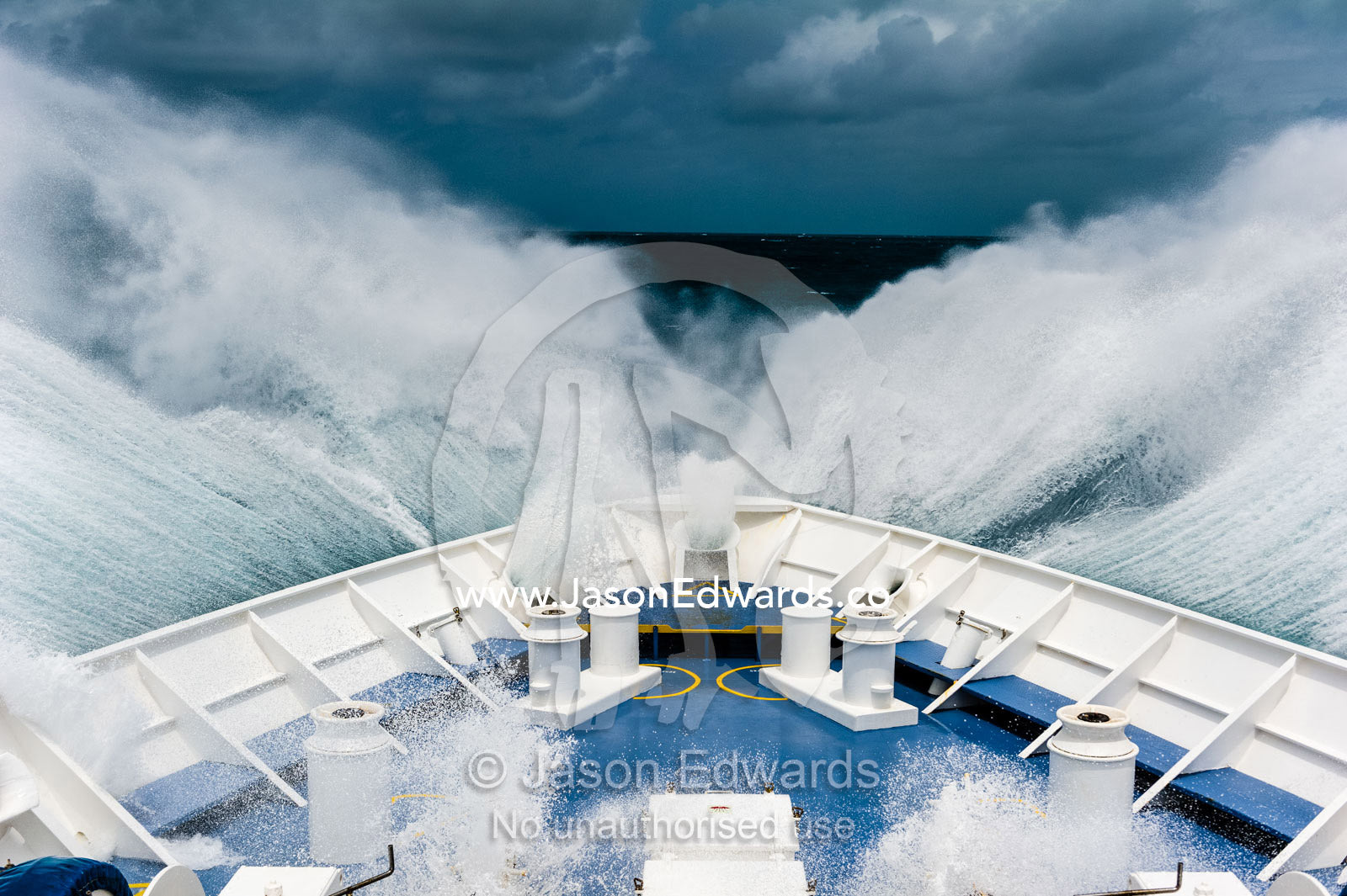 The bow of an expedition ship plows through breaking waves in the open sea. Arafura Sea, The Torres Strait, Papua, Indonesia