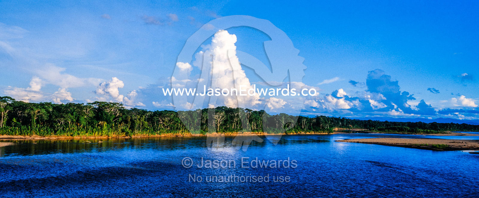 Billowing rain clouds rise above the Amazon rainforest and a wide sweeping river. Tambopata Research Centre, Tambopota River, Tambopata National Reserve, Peru