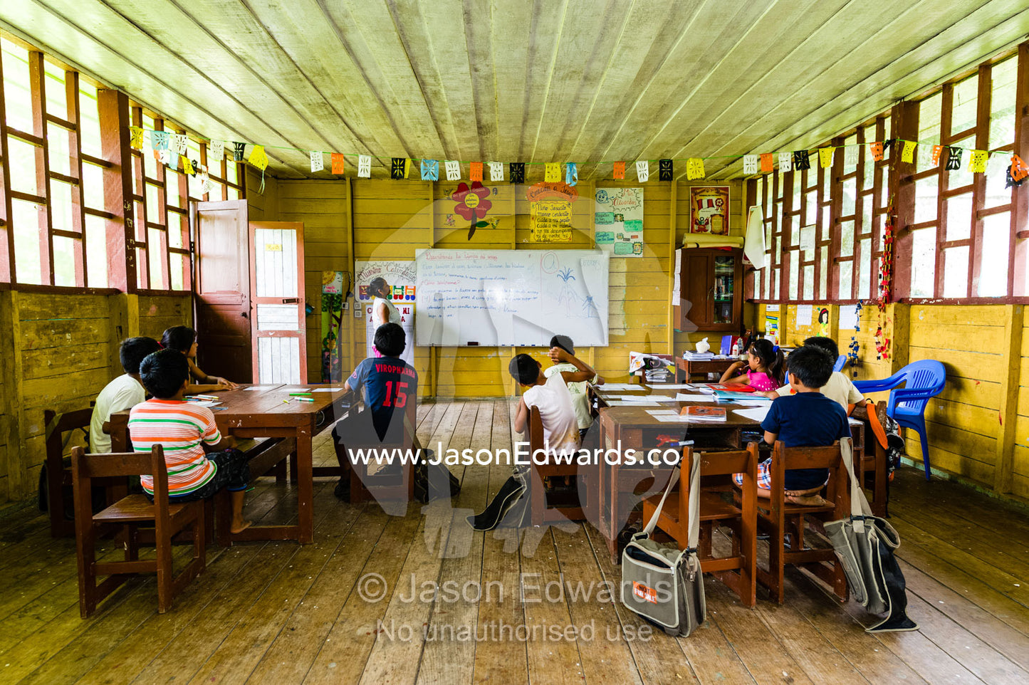 A teacher and her students in a school classroom in an Amazon village. Boca Pariamanu Native Community, Madre de Dios Region, Peru