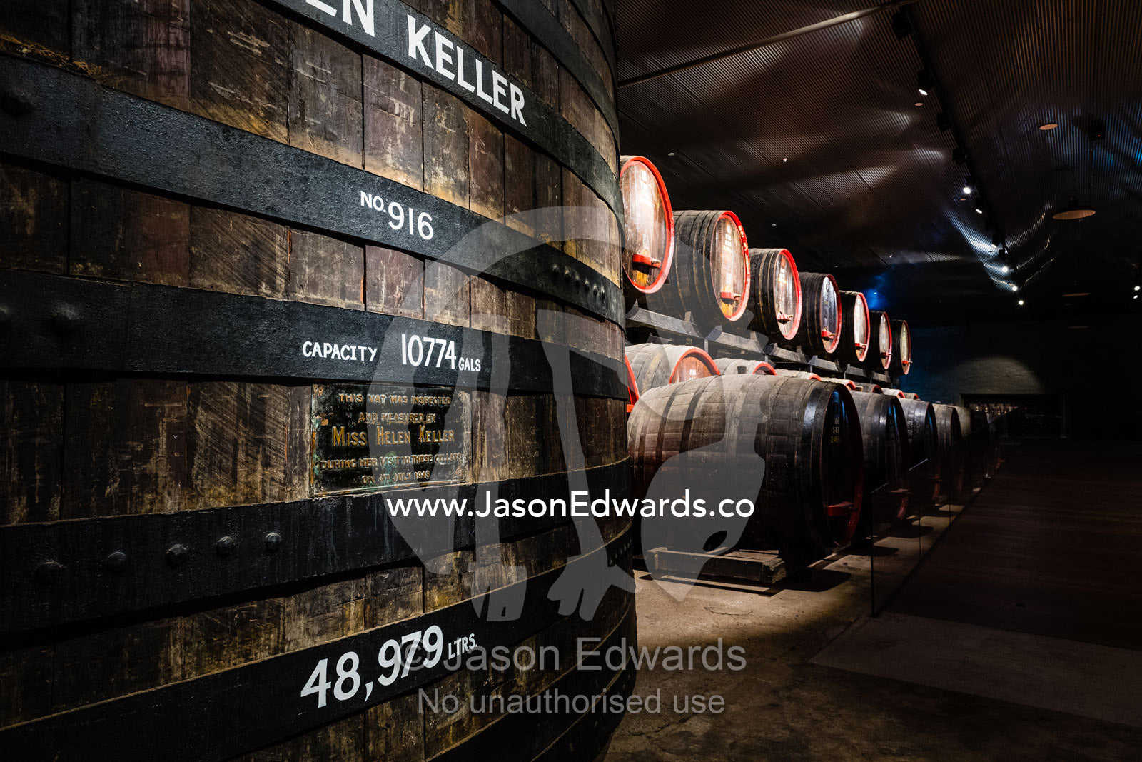 A row of wine barrels and vats stored in a climate controlled underground tunnel. Rosslyn Park, Adelaide, South Australia, Australia