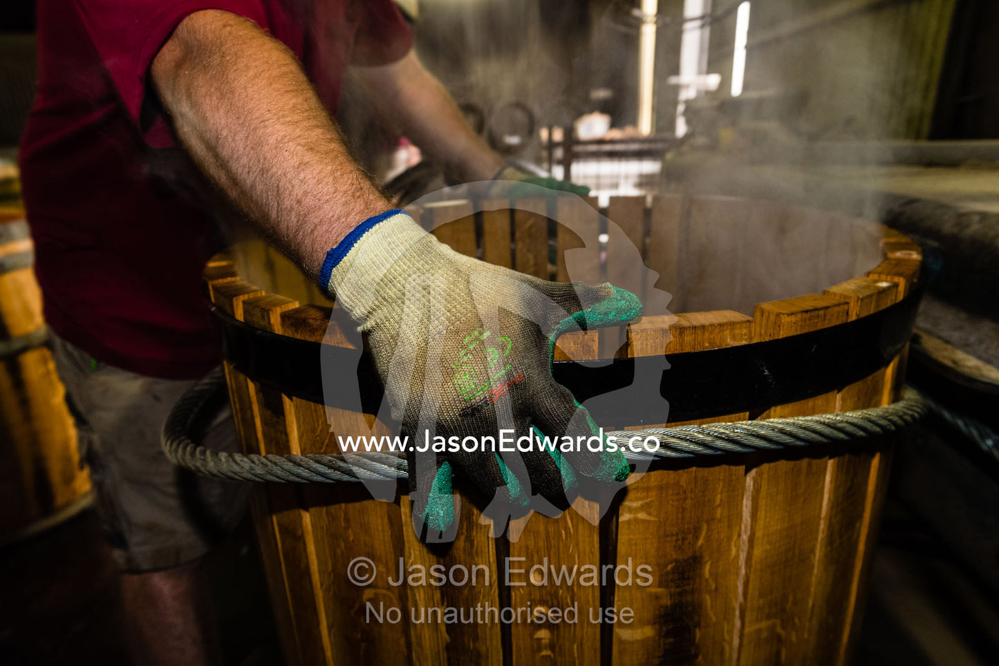 Steaming French Oak staves are pulled into shape using a cable winch to make a wine barrel. Tununda, South Australia, Australia