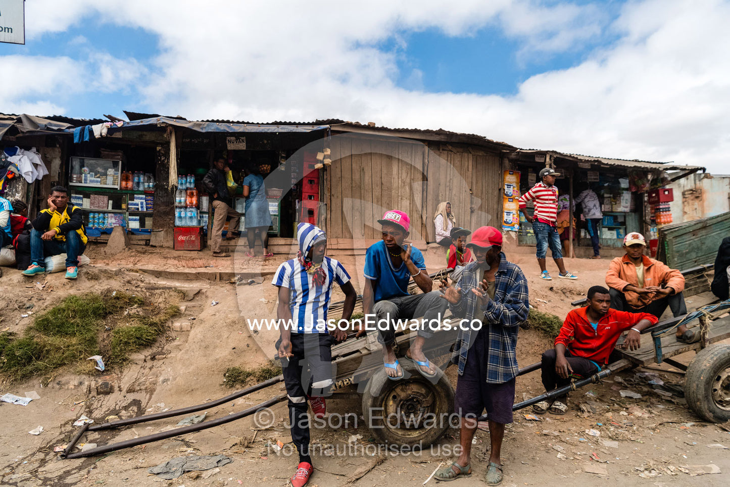 Young men in a roadside village wait with their trolleys to deliver loads of handmade bricks for construction. Antananarivo, Madagascar