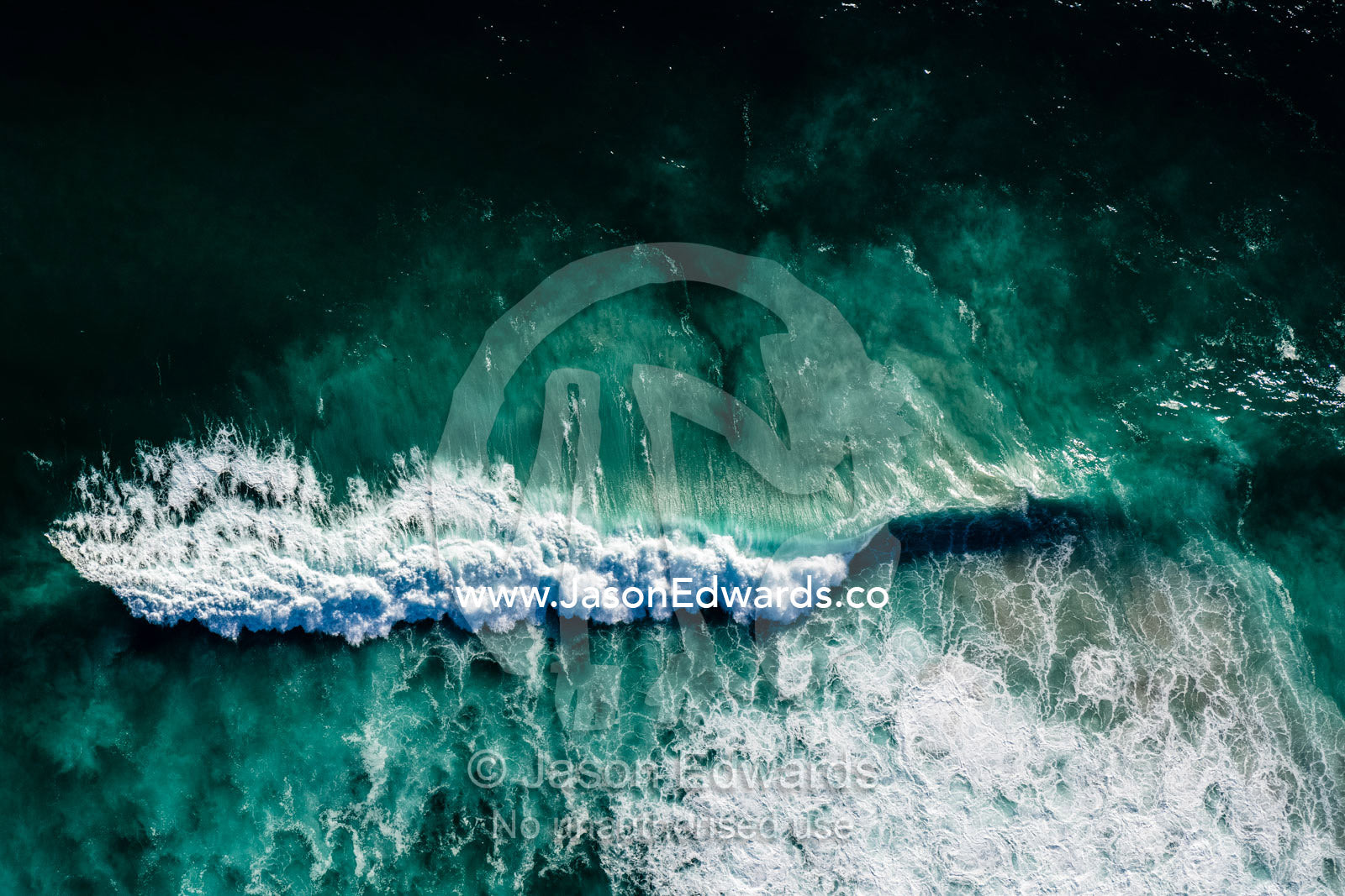 An aerial view of a wave breaking in the sandy shallows. Table Mountain National Park, South Africa