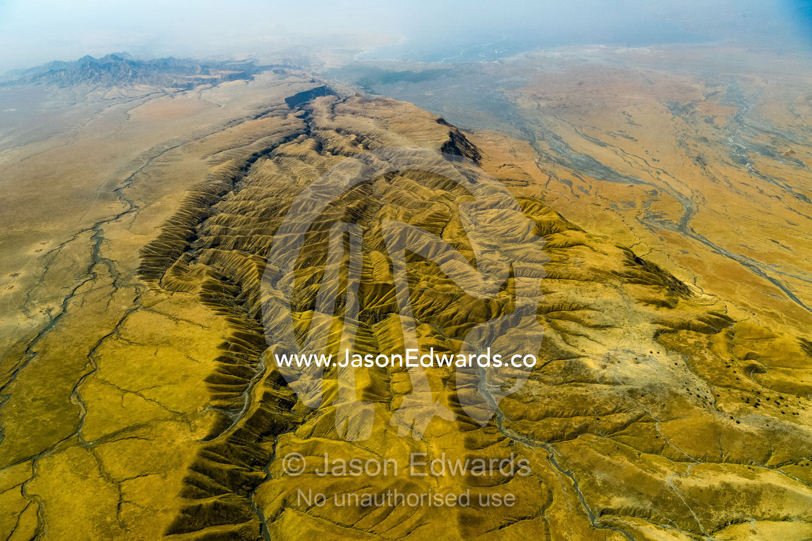 An aerial view of erosion on grass covered lava flows descending the slopes of an active volcano. Crater Highlands, Ngorongoro Hig, African Rift Valley , Serengeti National Park, Tanzania