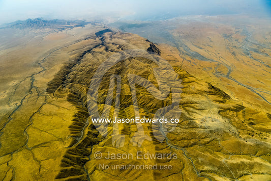 An aerial view of erosion on grass covered lava flows descending the slopes of an active volcano. Crater Highlands, Ngorongoro Hig, African Rift Valley , Serengeti National Park, Tanzania