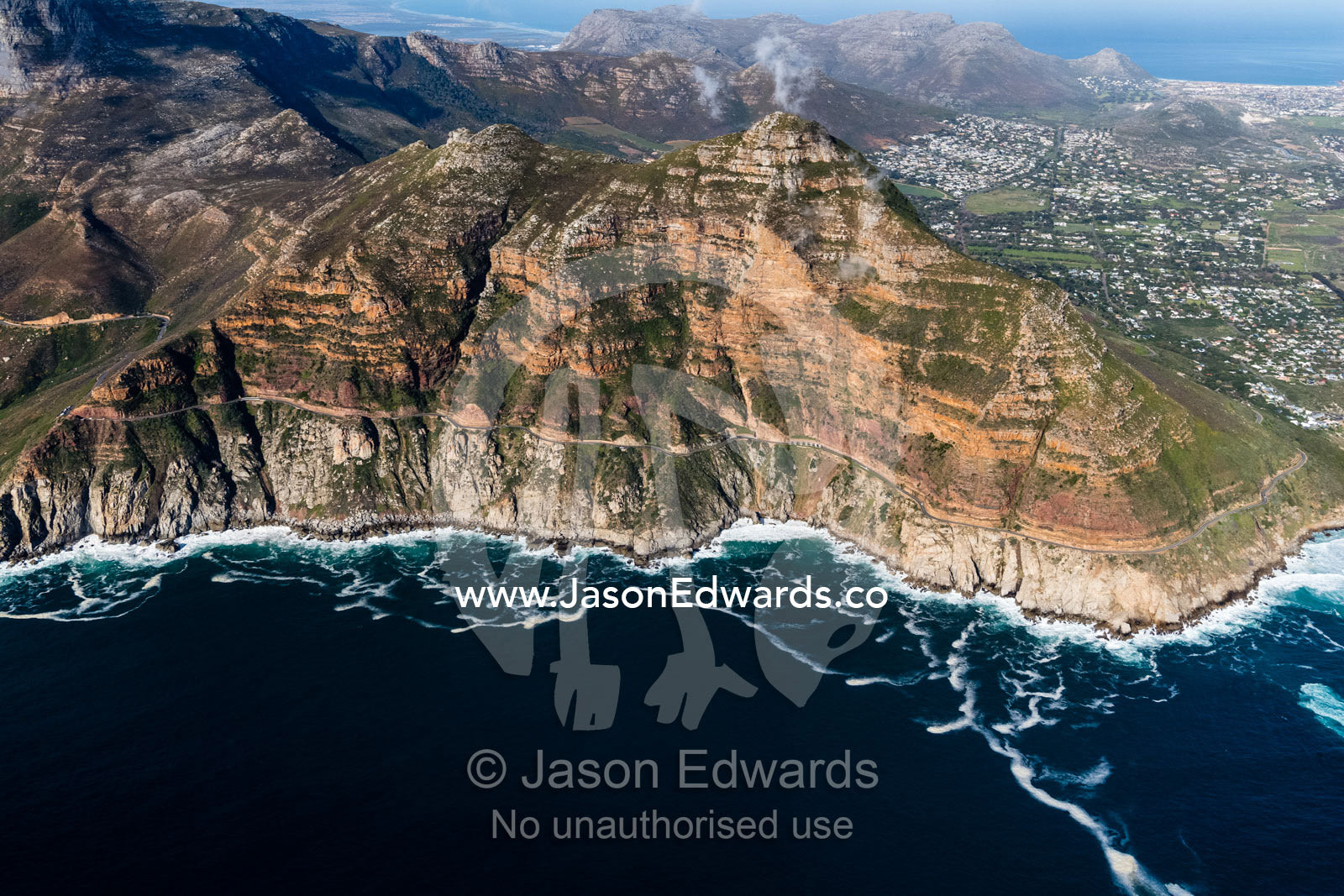The winding road of Chapmans Peak Drive passes beneath sheer cliffs. Table Mountain National Park, South Africa