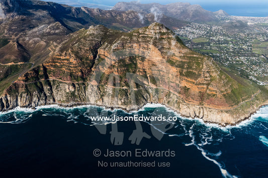 The winding road of Chapmans Peak Drive passes beneath sheer cliffs. Table Mountain National Park, South Africa