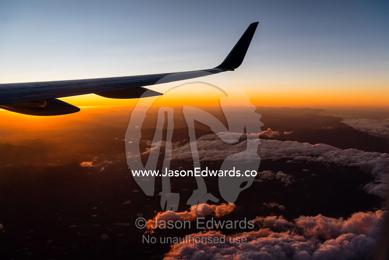 A jet wing flies into a blazing dawn above South Africa. Cape Town, Western Cape, South Africa