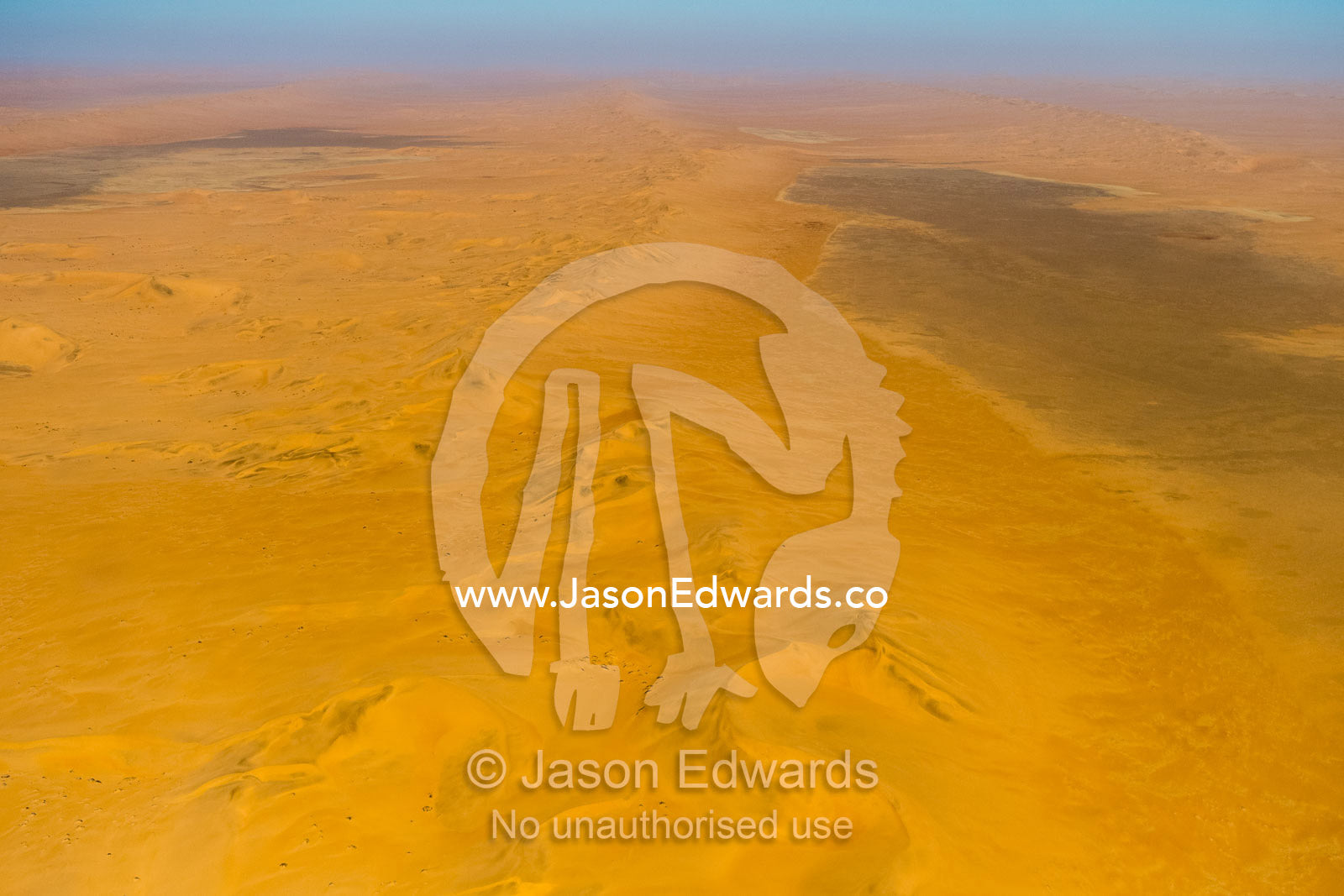 An aerial view of a sea of sand dunes disappearing into the distant horizon. Namib Desert, Diamond Coast, Skeleton Coast, Namib-Naukluft National Park, Namibia