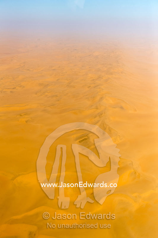 An aerial view of a sea of sand dunes disappearing into the distant horizon. Namib Desert, Diamond Coast, Skeleton Coast, Namib-Naukluft National Park, Namibia