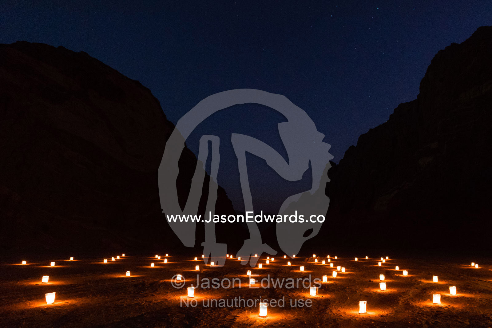 A field of candles lead a path down a desert gorge at night. Namib-Naukluft National Park, Namibia