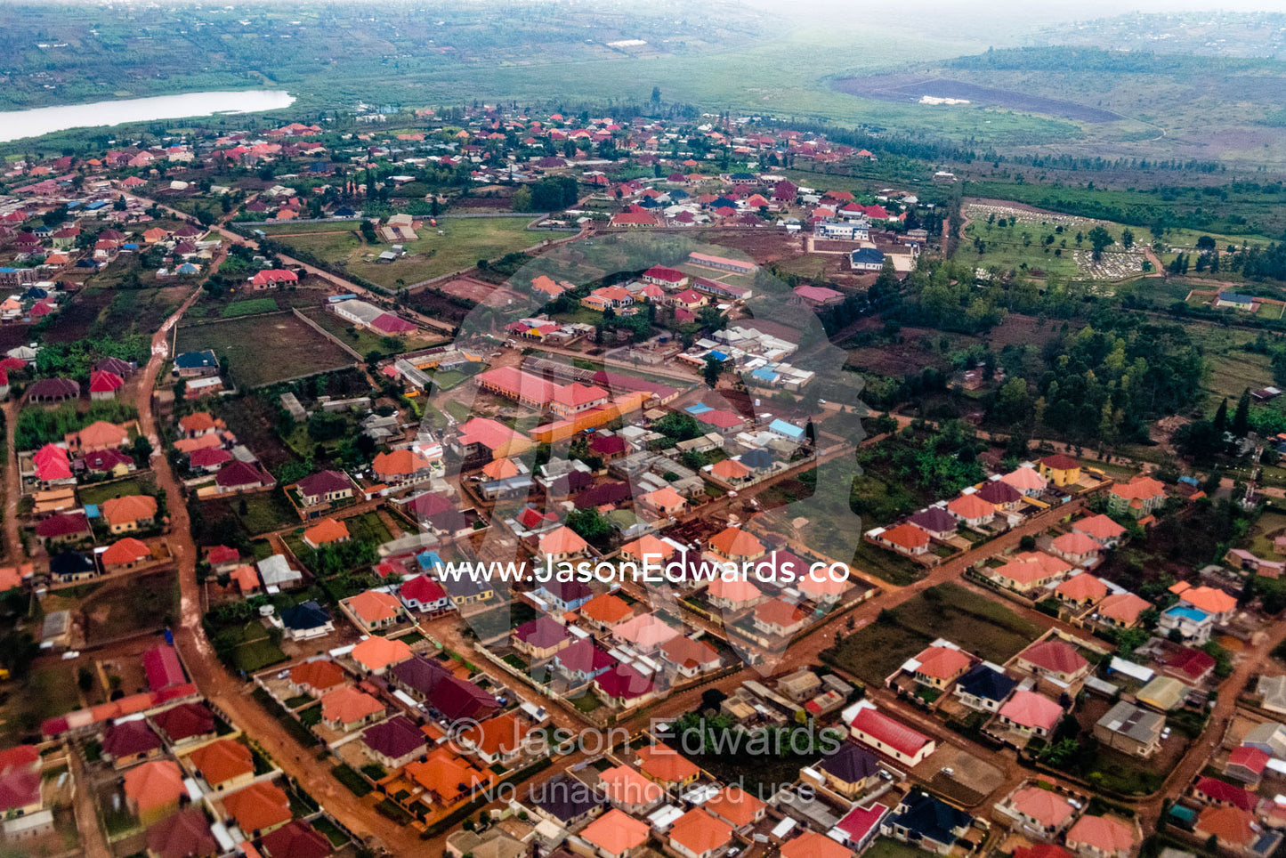 An aerial view of a town with corrugated tin roofs turned ochre by volcanic soil. Kigali, Rwanda