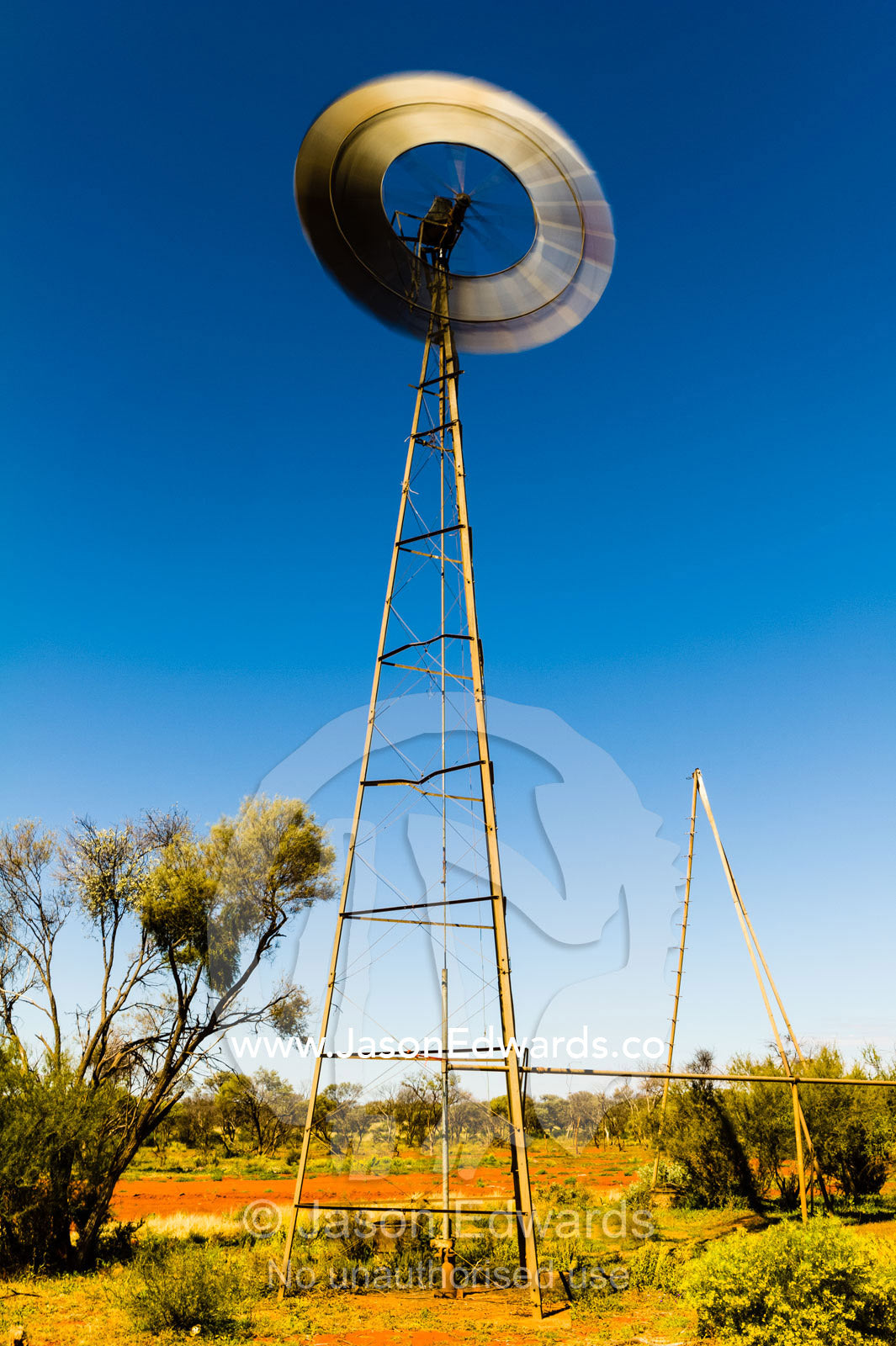The blades of a windmill spinning in the wind on a remote outback cattle station in the desert. Coober Pedy, Wintinna Station, South Australia, Australia