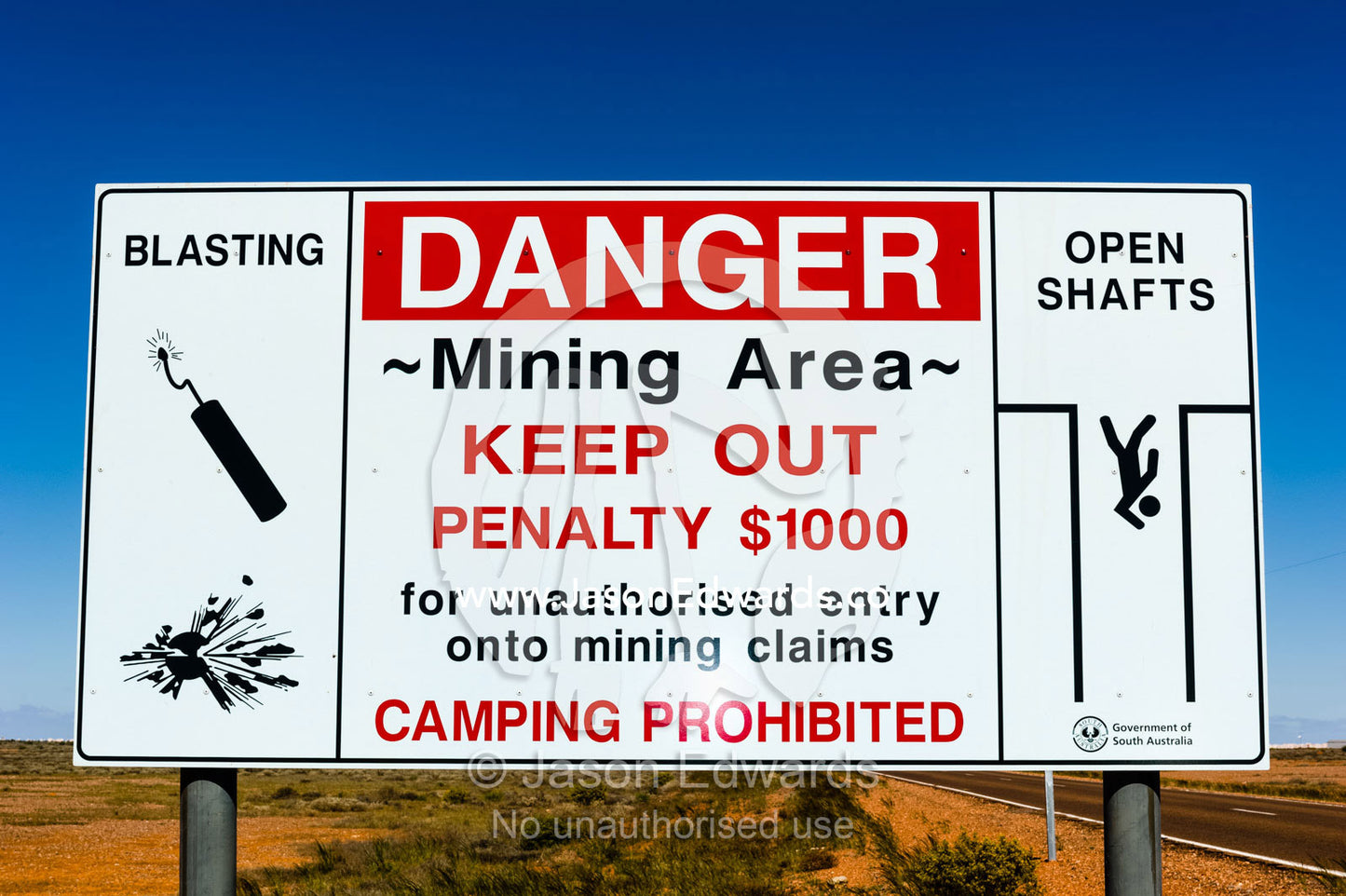 A warning sign illustrating opal mine shafts and explosive dangers. Coober Pedy, South Australia, Australia