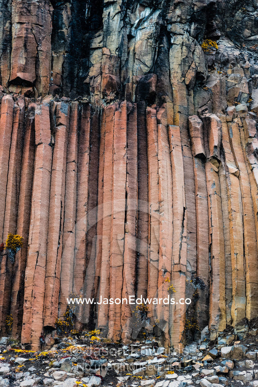 Hexagonal lava basalt column formations rising up a sheer cliff face in the arctic Vikingbukt, Viking Bay, Vikingbukta, Scoresby Sound, Greenland