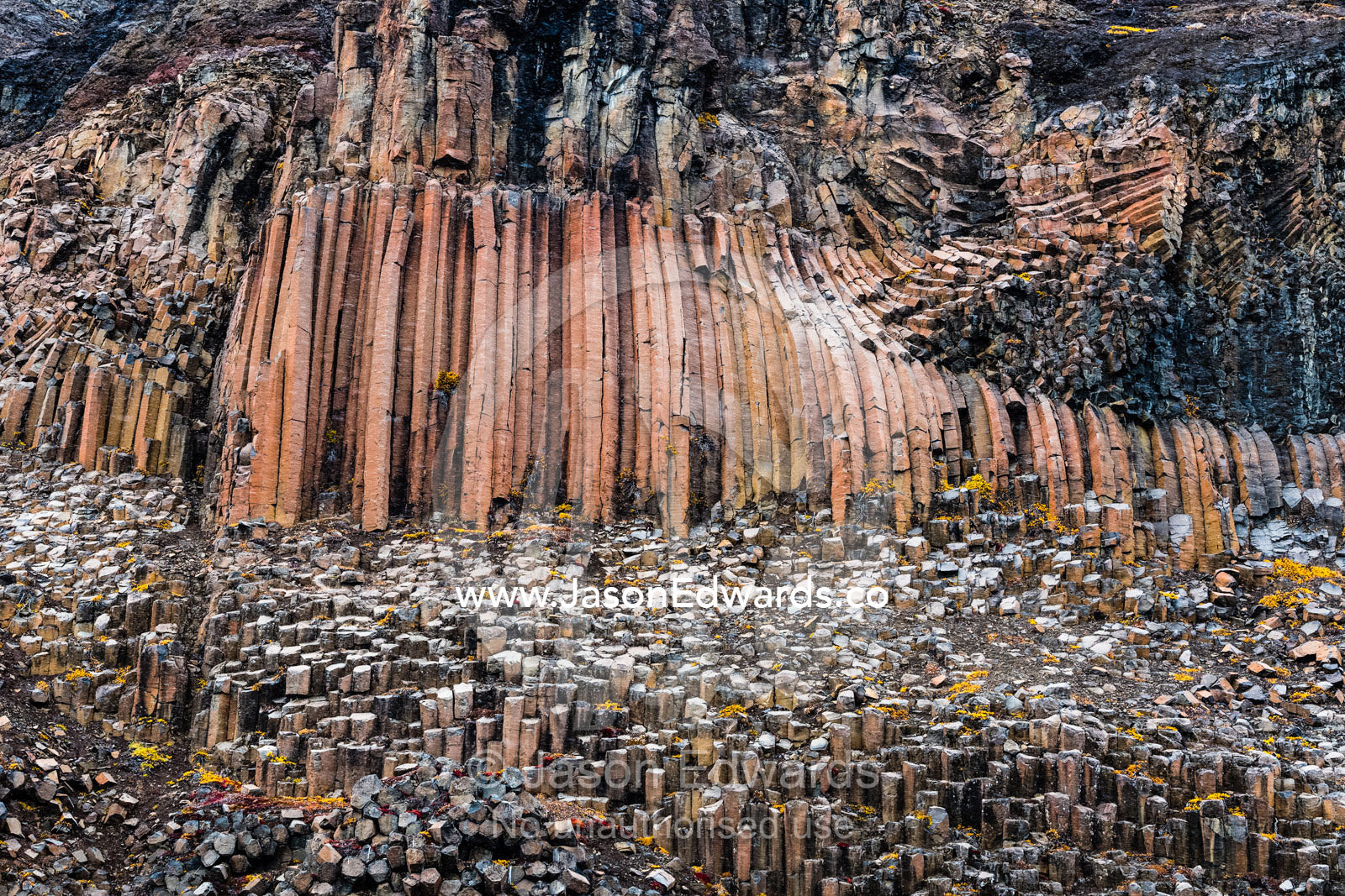 Hexagonal lava basalt column formations rising up a sheer cliff face in the arctic Vikingbukt, Viking Bay, Vikingbukta, Scoresby Sound, Greenland