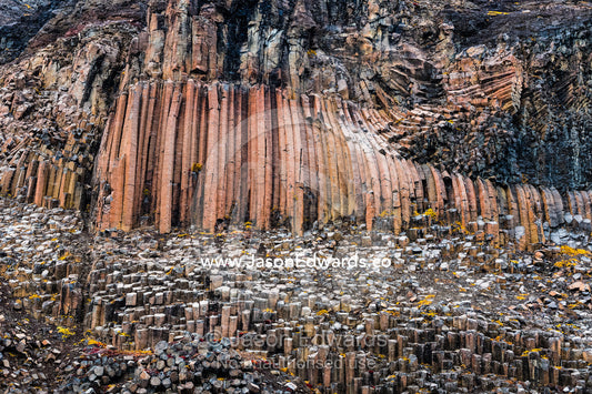 Hexagonal lava basalt column formations rising up a sheer cliff face in the arctic Vikingbukt, Viking Bay, Vikingbukta, Scoresby Sound, Greenland