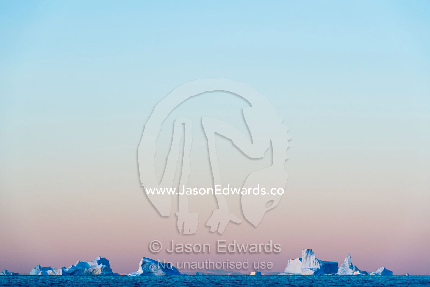 Pastel pink and purple lights Crevasse jagged icebergs rising from the arctic sea at sunset. Milne Land, Hall Bredning Fjord, Scoresby Sound, Greenland