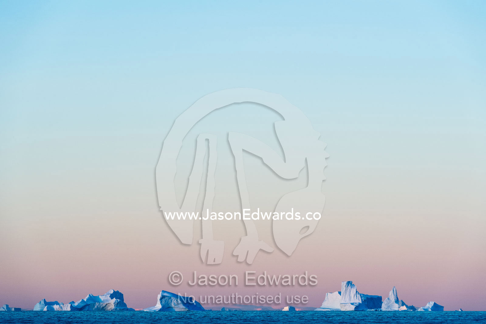 Pastel pink and purple lights Crevasse jagged icebergs rising from the arctic sea at sunset. Milne Land, Hall Bredning Fjord, Scoresby Sound, Greenland