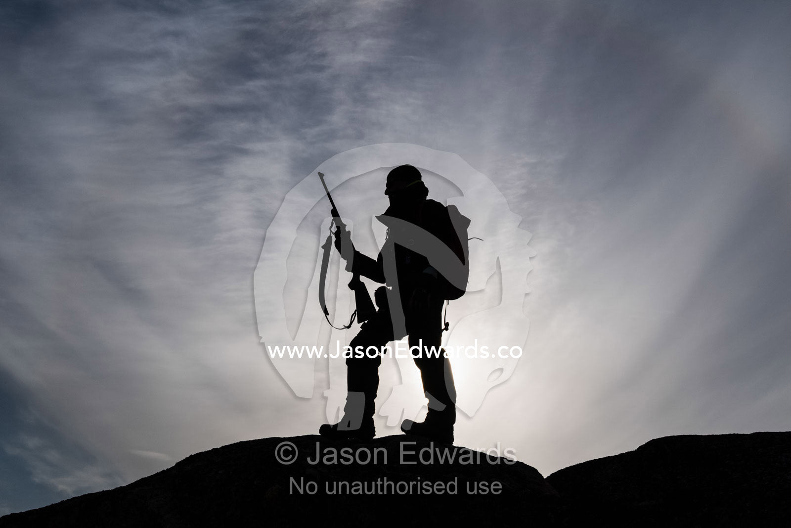 An arctic guide silhouette on a mountain top with a hunting rifle. Milne Land, Jytte Havn, Bjorne Islands, Scoresby Sound, Greenland