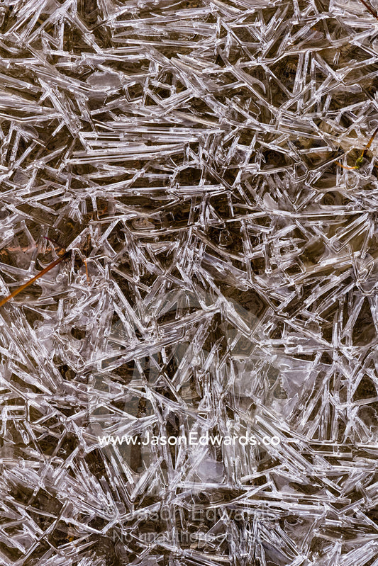 A mosaic of frozen ice crystals create geometric patterns on the surface of a freshwater stream in the arctic tundra. Renland, Milne Land, ) Fjord, Island Fjord, Rype Fjor, Scoresby Sound, Greenland