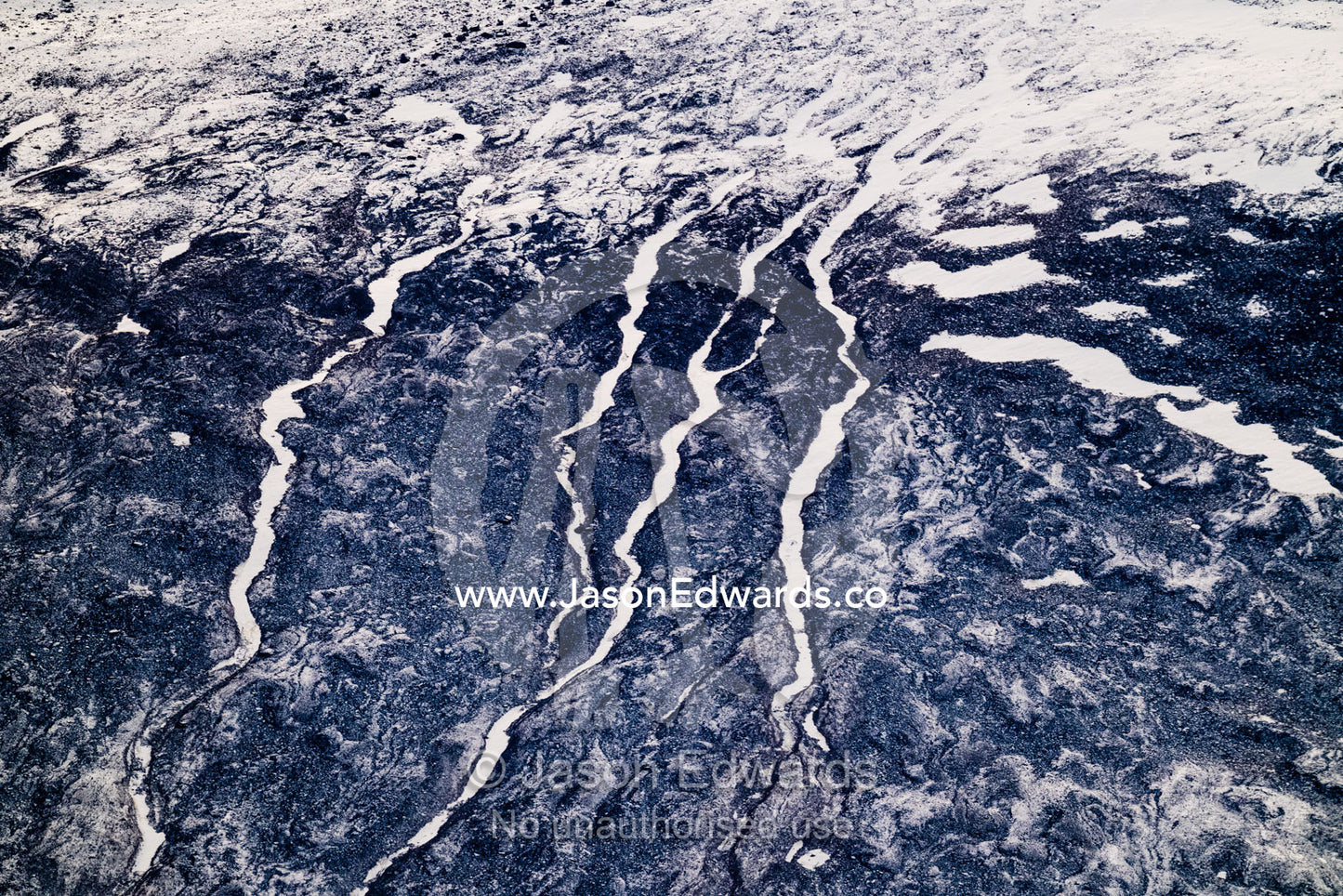 Rivers of snow and ice flow down a barren mountainside like snakes in the arctic. Scoresby Sound, Greenland