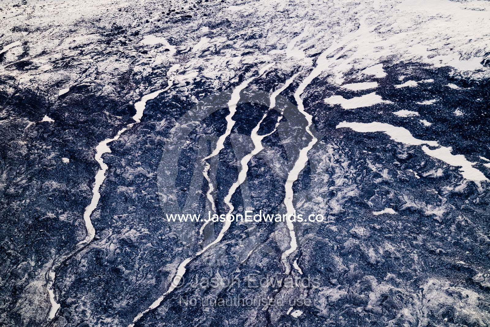 Rivers of snow and ice flow down a barren mountainside like snakes in the arctic. Scoresby Sound, Greenland