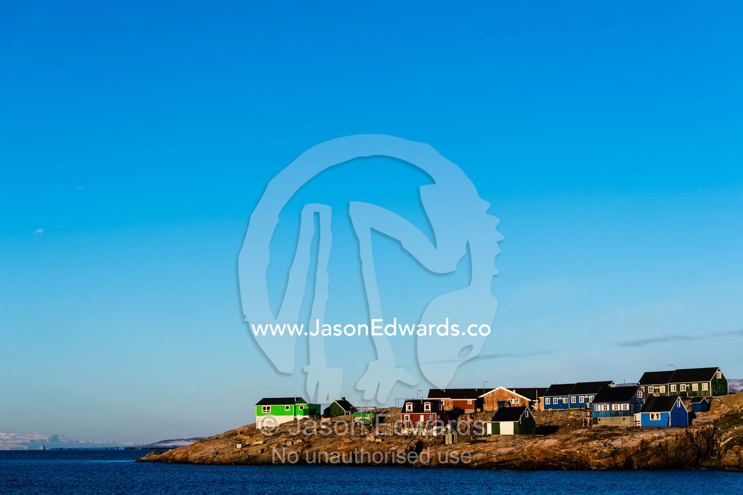 Dawn rises over an Inuit community of houses on a remote island in the Arctic. Sermersooq Municipality, Ittoqqottoormiit, Scoresby Sound, Greenland