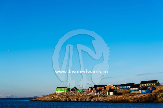 Dawn rises over an Inuit community of houses on a remote island in the Arctic. Sermersooq Municipality, Ittoqqottoormiit, Scoresby Sound, Greenland