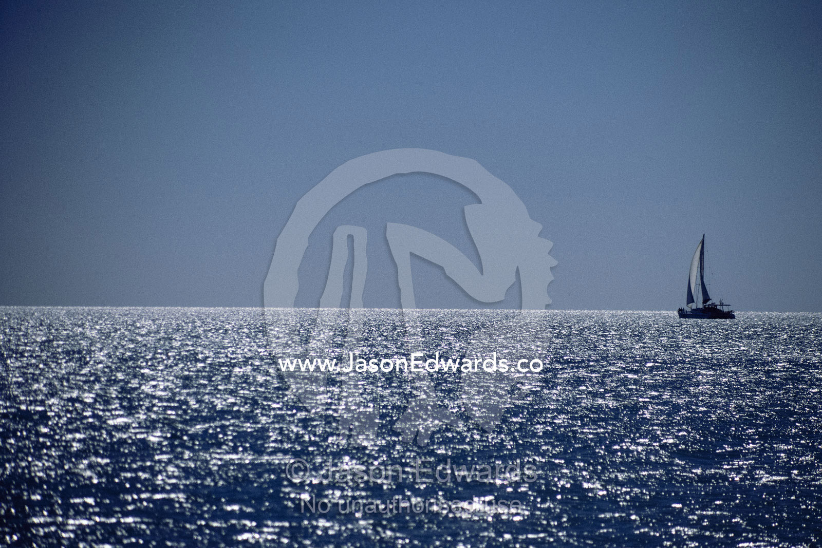 A sailboat on the sun-reflected waters of Shark Bay. Shark Bay, Western Australia, Australia.