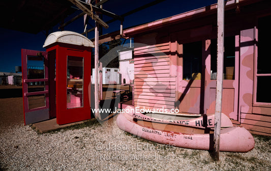 An antique telephone booth and canoes at Oodnadatta's Pink Roadhouse. Oodnadatta, South Australia, Australia.