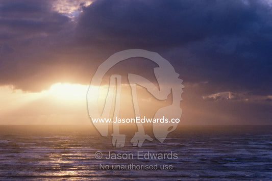 Sunlight bursts through clouds over the Southern Ocean. Coorong National Park, South Australia, Australia.
