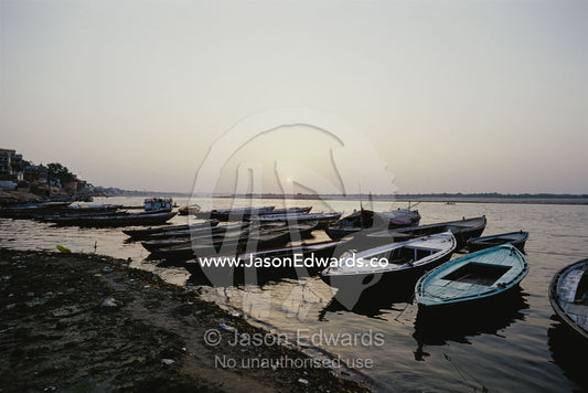 Tourist pilgrimage boats on shore at dawn. Varanasi, India.