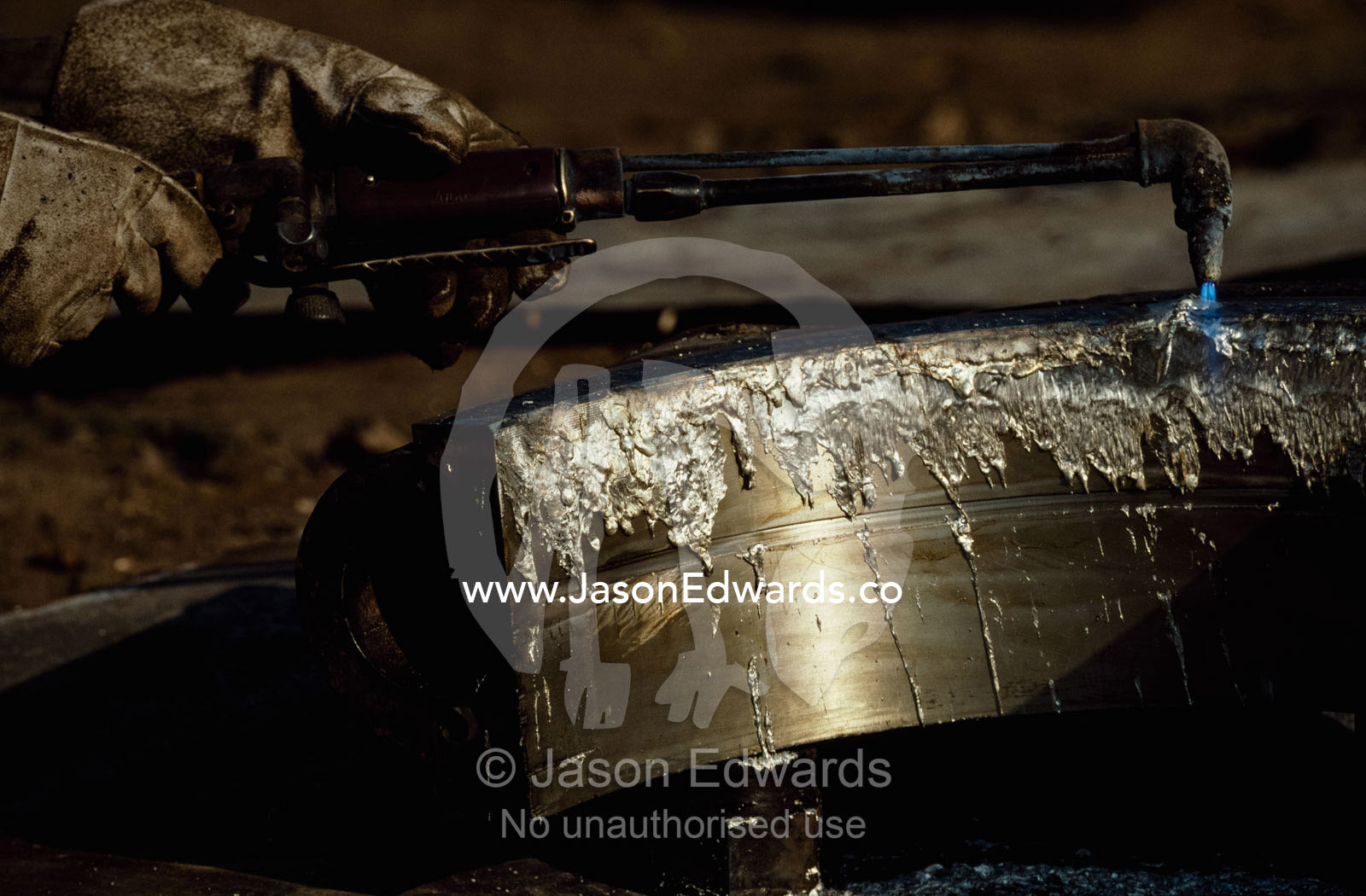 Silver is melted from the lining of an engine cylinder bore. Alang, India.
