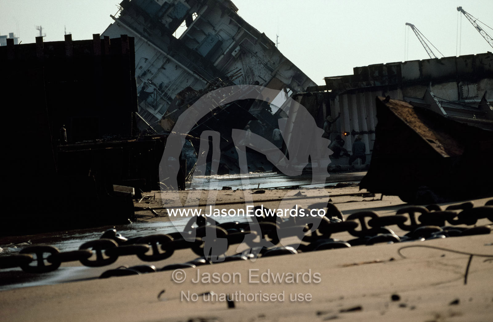 Low tide allows for laborers to work on steel previously submerged. Alang, India.