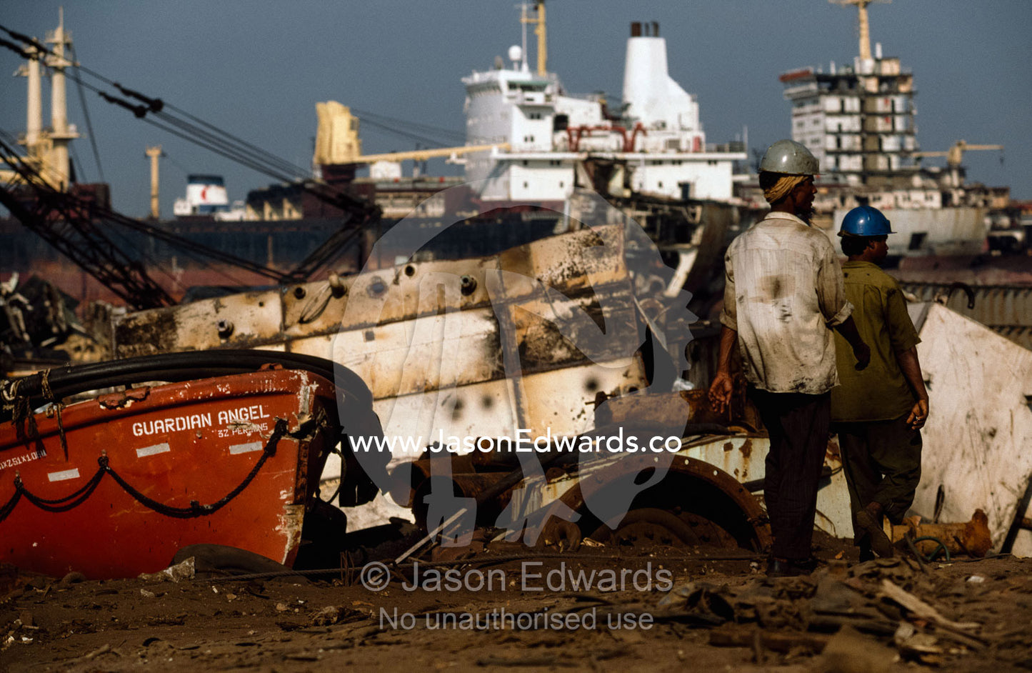 Laborers pass a lifeboat  which will be re-sold or recycled. Alang, India.